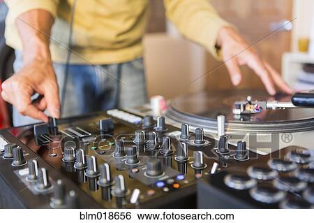Mixed race disc jockey using turntable in studio View Large Photo Image Stock Photograph - Mixed race disc jockey using turntable in studio. Fotosearch