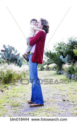 Mother holding toddler son outdoors View Large Photo Image Picture - Mother holding toddler son outdoors. Fotosearch