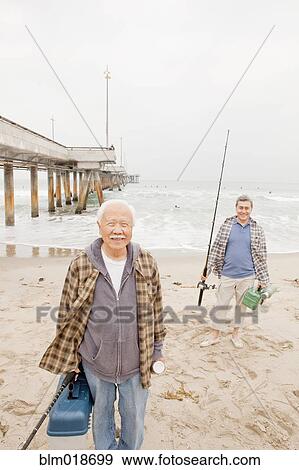 Stock Photo - Older men fishing together on beach. Fotosearch