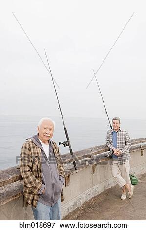 Older men fishing together on dock View Large Photo Image Stock Photo - Older men fishing together on dock. Fotosearch