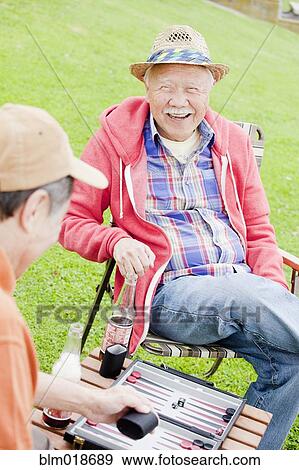 Older men playing backgammon outdoors View Large Photo Image Stock Photo - Older men playing backgammon outdoors. Fotosearch