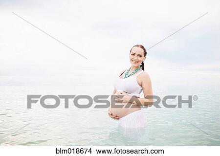 Pregnant Caucasian woman standing in water View Large Photo Image Picture - Pregnant Caucasian woman standing in water. Fotosearch