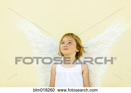Stock Image - Smiling girl wearing angel wings. Fotosearch