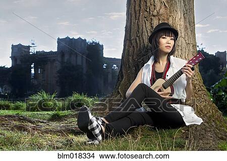 Thai woman playing guitar in park View Large Photo Image Picture - Thai woman playing guitar in park. Fotosearch