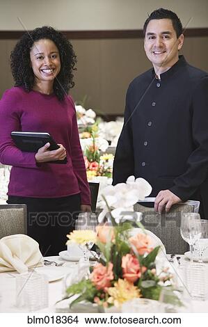 Picture - Waiter and businesswoman smiling in dining room. Fotosearch