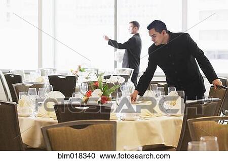 Waiters setting tables in dining room View Large Photo Image Stock Image - Waiters setting tables in dining room. Fotosearch