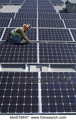 Worker examining solar panels outdoors View Large Photo Image Stock Photo - Worker examining solar panels outdoors. Fotosearch