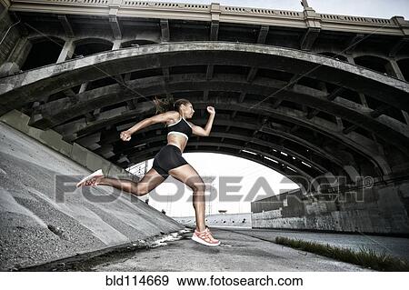 Stock Photo - African American runner under overpass. Fotosearch