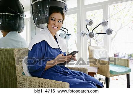 Stock Photograph - Asian woman having hair done in salon. Fotosearch