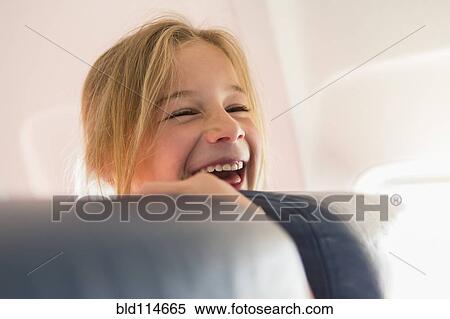 Caucasian girl laughing on airplane View Large Photo Image Stock Photography - Caucasian girl laughing on airplane. Fotosearch