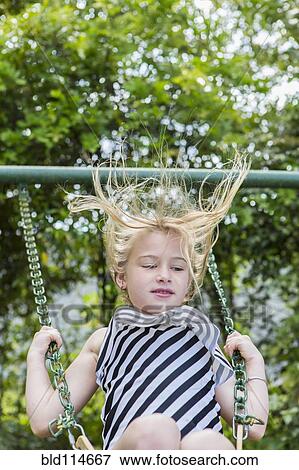 Caucasian girl playing on swing in park View Large Photo Image Stock Photo - Caucasian girl playing on swing in park. Fotosearch