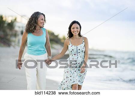 Caucasian mother and daughter walking on beach View Large Photo Image Stock Photo - Caucasian mother and daughter walking on beach. Fotosearch