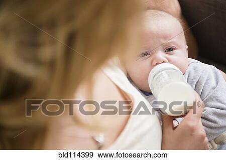Stock Photo - Caucasian mother feeding baby. Fotosearch
