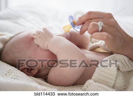 Caucasian mother giving baby pacifier View Large Photo Image Stock Image - Caucasian mother giving baby pacifier. Fotosearch