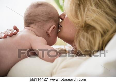 Stock Photo - Caucasian mother kissing baby. Fotosearch