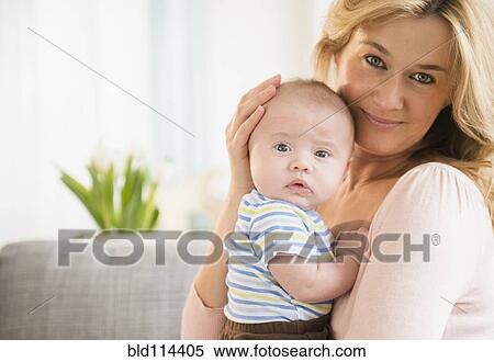Stock Photography - Caucasian mother smiling with baby. Fotosearch