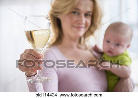 Caucasian mother with baby having glass of wine View Large Photo Image Picture - Caucasian mother with baby having glass of wine. Fotosearch