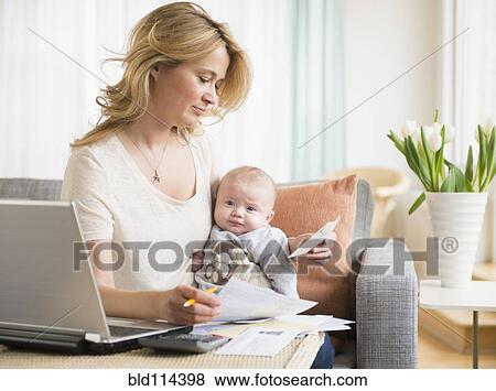 Caucasian mother with baby paying bills View Large Photo Image Stock Photo - Caucasian mother with baby paying bills. Fotosearch