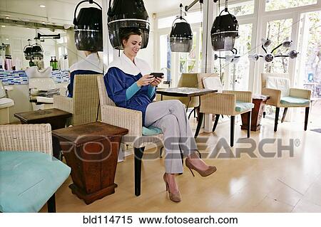 Stock Photography - Caucasian woman having hair done in salon. Fotosearch