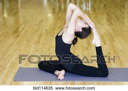 Stock Photography - Caucasian woman practicing yoga in studio. Fotosearch