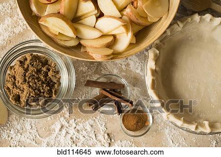 Stock Photography - Close up of apples, spices and empty pie shell. Fotosearch