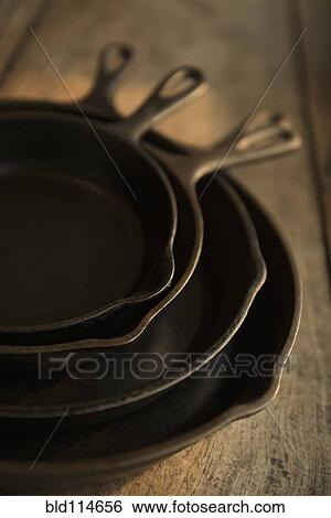 Empty cast iron pans on wooden board View Large Photo Image Stock Photograph - Empty cast iron pans on wooden board. Fotosearch