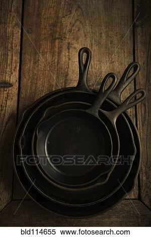 Empty cast iron pans on wooden board View Large Photo Image Stock Photography - Empty cast iron pans on wooden board. Fotosearch