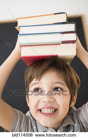 Hispanic boy balancing books on head View Large Photo Image Stock Photo - Hispanic boy balancing books on head. Fotosearch