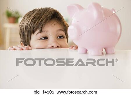 Hispanic boy examining piggy bank View Large Photo Image Stock Photography - Hispanic boy examining piggy bank. Fotosearch