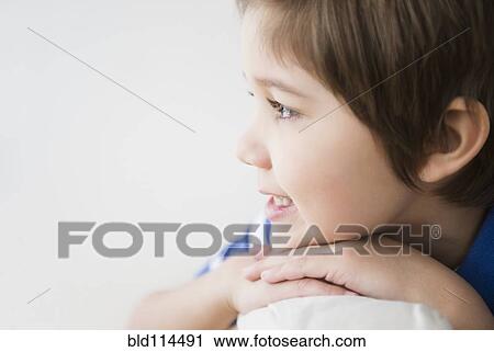 Stock Image - Hispanic boy resting chin on hands. Fotosearch