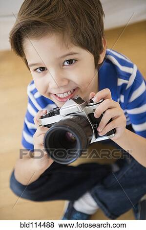 Stock Photo - Hispanic boy taking pictures. Fotosearch