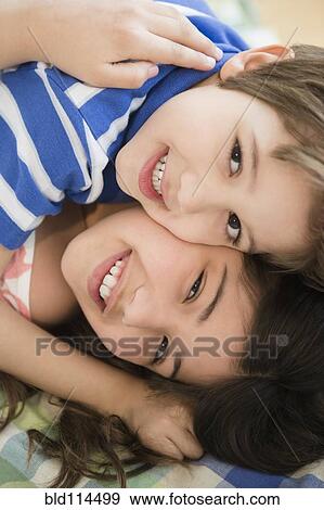 Hispanic children hugging on bed View Large Photo Image Stock Photo - Hispanic children hugging on bed. Fotosearch