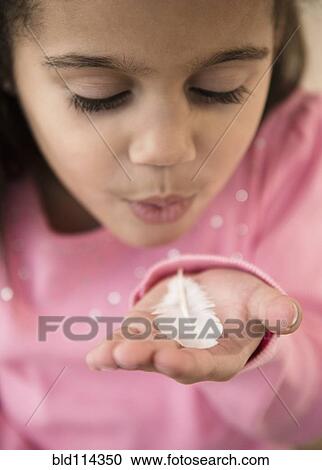 Hispanic girl blowing on feather View Large Photo Image Stock Image - Hispanic girl blowing on feather. Fotosearch
