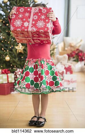 Hispanic girl holding Christmas gift View Large Photo Image Stock Image - Hispanic girl holding Christmas gift. Fotosearch