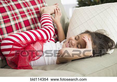 Hispanic girl laying on sofa View Large Photo Image Picture - Hispanic girl laying on sofa. Fotosearch
