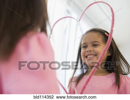 Hispanic girl making lipstick heart in mirror View Large Photo Image Stock Image - Hispanic girl making lipstick heart in mirror. Fotosearch