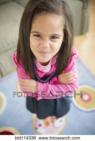 Hispanic girl pouting in living room View Large Photo Image Stock Photo - Hispanic girl pouting in living room. Fotosearch