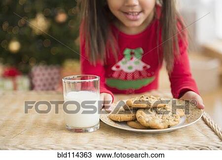 Hispanic girl setting out milk and cookies for Santa View Large Photo Image Stock Image - Hispanic girl setting out milk and cookies for Santa. Fotosearch