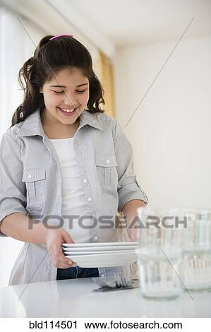 Stock Image - Hispanic girl setting table. Fotosearch