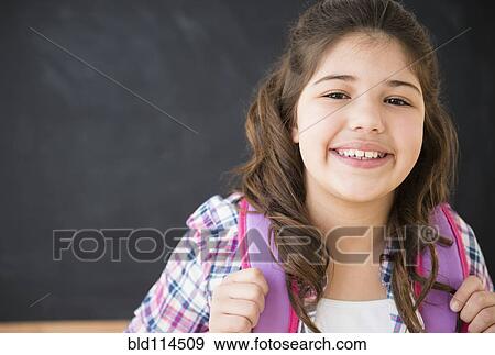 Stock Photo - Hispanic girl smiling in classroom. Fotosearch