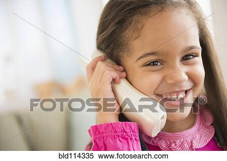 Hispanic girl talking on telephone View Large Photo Image Stock Photography - Hispanic girl talking on telephone. Fotosearch