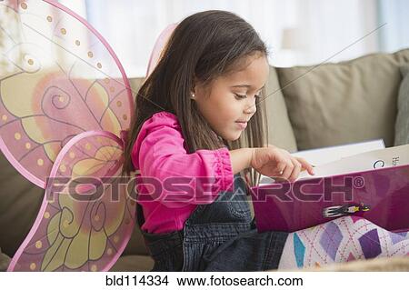 Hispanic girl wearing fairy wings on sofa View Large Photo Image Picture - Hispanic girl wearing fairy wings on sofa. Fotosearch