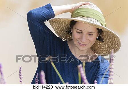 Stock Image - Hispanic woman wearing sun hat outdoors. Fotosearch