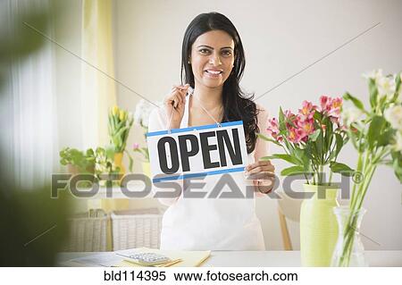 Indian florist holding 'open' sign View Large Photo Image Stock Photography - Indian florist holding 'open' sign. Fotosearch