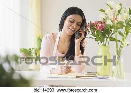 Stock Image - Indian florist talking on telephone. Fotosearch