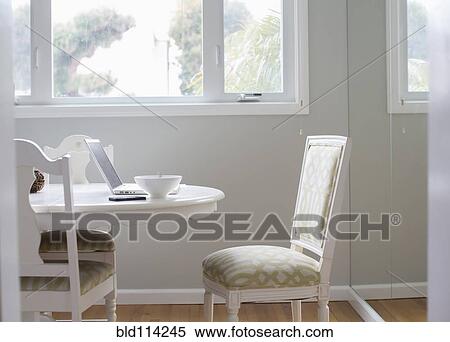 Stock Photography - Laptop and bowl on dining room table. Fotosearch