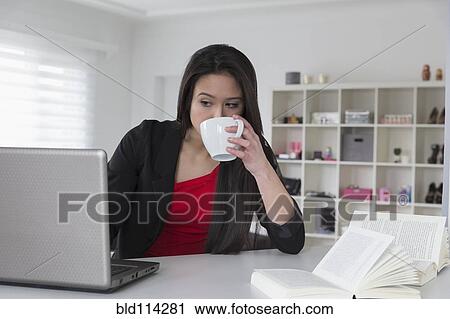 Stock Image - Mixed race businesswoman using laptop. Fotosearch