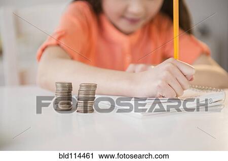 Stock Image - Mixed race girl doing homework. Fotosearch