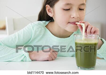 Mixed race girl drinking green smoothie View Large Photo Image Stock Image - Mixed race girl drinking green smoothie. Fotosearch