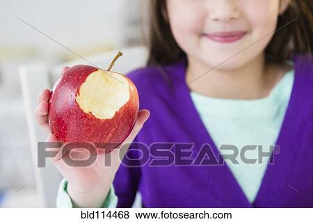Stock Photo - Mixed race girl eating apple. Fotosearch